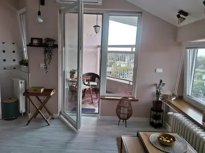 a living room with a sliding glass door and a table at Pogled Ada 1 in Belgrade
