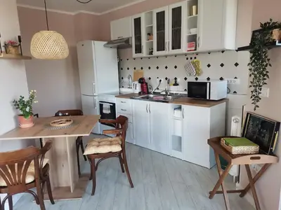 a kitchen with white cabinets and a table and chairs at Pogled Ada 1 in Belgrade