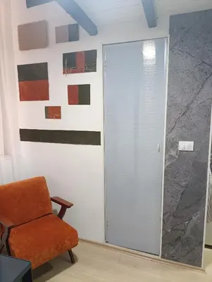 a room with a sliding door and a chair at Princip Apartman in Belgrade