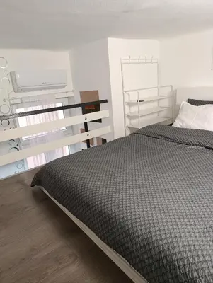 a bedroom with a bed with a black comforter at Princip Apartman in Belgrade
