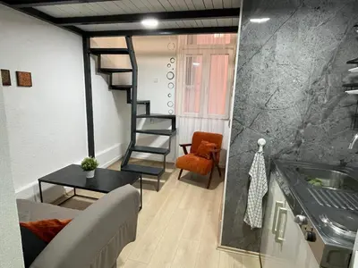 a room with a staircase and a sink and a couch at Princip Apartman in Belgrade