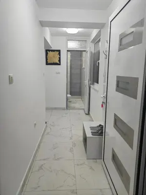 a hallway with white walls and a tile floor at Apartmani B&R in Lazarevac