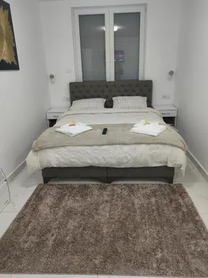 a bedroom with a large bed with two night stands at Apartmani B&R in Lazarevac
