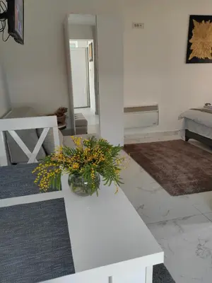 a white table with a vase of flowers on it at Apartmani B&R in Lazarevac
