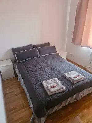 a bedroom with a bed with two towels on it at ETA Apartments in Belgrade