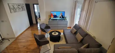 a living room with a couch and chairs and a tv at ETA Apartments in Belgrade