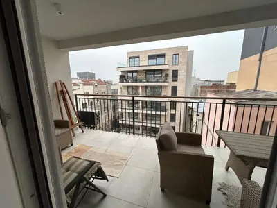 a balcony with a table and chairs and a view of a building at Apartman Jevremov Kutak in Belgrade