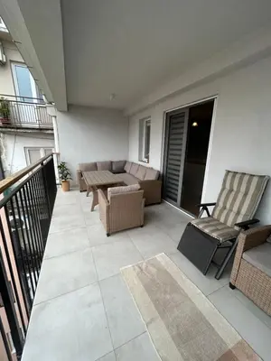 a patio with a couch and chairs on a balcony at Apartman Jevremov Kutak in Belgrade