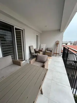a balcony with a couch and chairs on a building at Apartman Jevremov Kutak in Belgrade