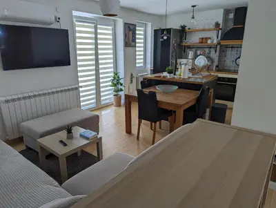 a living room with a table and a dining room at Apartman Jevremov Kutak in Belgrade