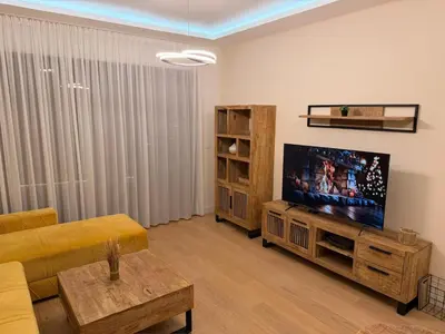 a living room with a couch and a flat screen tv at Belgrade Waterfront KINGS Park Residences in Belgrade