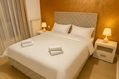 a bedroom with a large white bed with two lamps at Belgrade Waterfront KINGS Park Residences in Belgrade