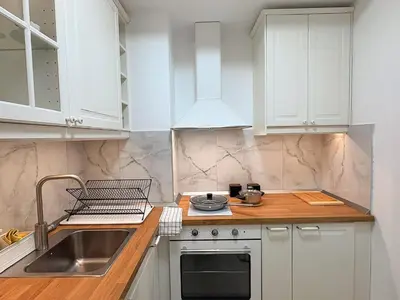 a kitchen with white cabinets and a sink at Room 66