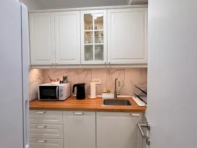 a kitchen with white cabinets and a microwave at Room 66