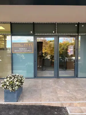 a building with glass doors and a potted plant at Room 66