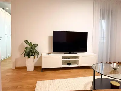 a living room with a tv on a white cabinet at Room 66