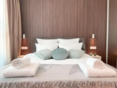 a bed with two pillows and two towels on it at Eterna Premium Apartment 1 Bedroom in Sajmište