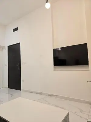 a white room with a tv on a wall at White Queen in Bukorovac
