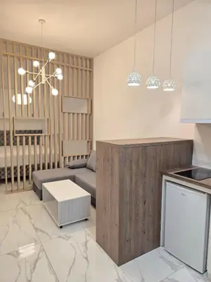 a kitchen and living room with a couch and a table at White Queen in Bukorovac