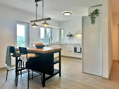 a kitchen with a island in the middle of a room at Mali Raj in Mala Ivanča