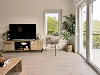 a living room with a tv and a chair at Mali Raj in Mala Ivanča