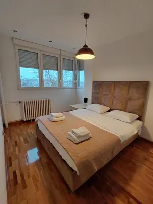 a bedroom with a large bed with two towels on it at Fontana in Belgrade