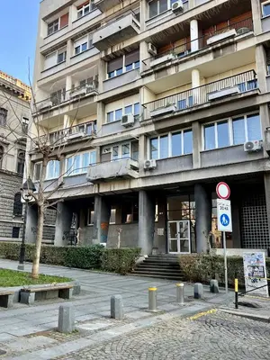a large building with windows and a street sign in front at City Heart Studio, City Center in Belgrade