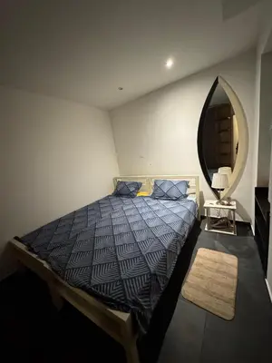 a bedroom with a bed and a round mirror at BelgradeCenterVibe in Belgrade