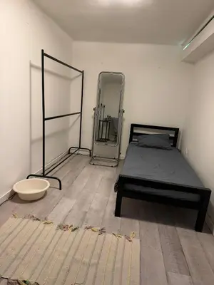 a bedroom with a bed and a mirror on the floor at BelgradeCityVibe in Belgrade