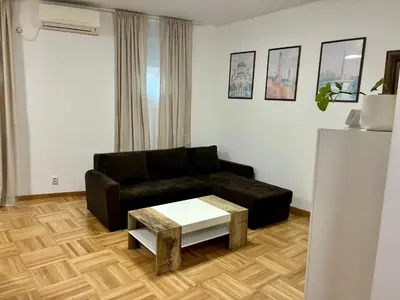 a living room with a black couch and a coffee table at VHome in Belgrade
