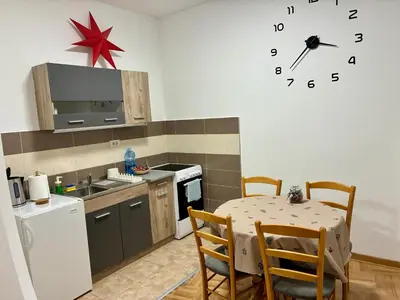 a kitchen with a table and a clock on the wall at VHome in Belgrade