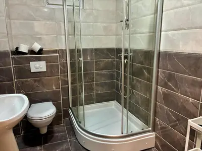 a bathroom with a shower and a toilet and a sink at VHome in Belgrade