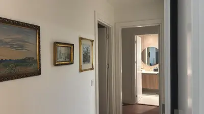 a hallway with paintings and a mirror on a wall at BW Premium Apartment Wolf-free parking in Belgrade