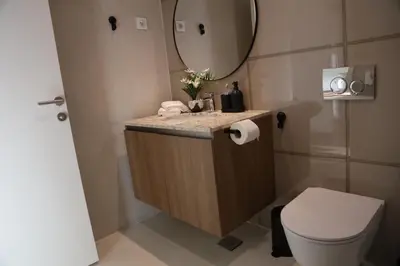 a bathroom with a sink and a toilet and a mirror at BW Premium Apartment Wolf-free parking in Belgrade