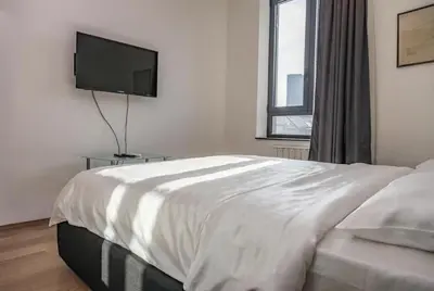 a bedroom with a bed and a flat screen tv at BW Premium Apartment Wolf-free parking in Belgrade