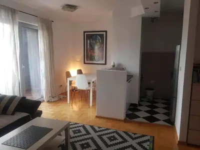 a living room with a table and a white refrigerator at Botanical Garden in Belgrade