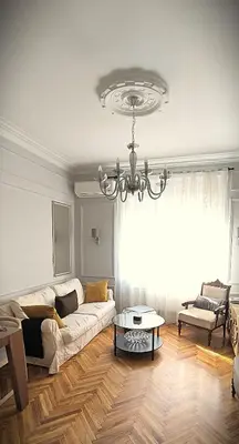 a living room with a white couch and a chandelier at Apartment JADE Vracar, Belgrade in Belgrade