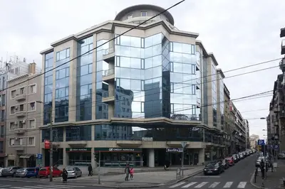a large glass building on the corner of a street at Apartment JADE Vracar, Belgrade in Belgrade