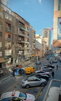 a busy city street with cars parked in front of buildings at Apartment JADE Vracar, Belgrade in Belgrade