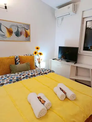 a bedroom with a yellow bed with towels on it at Urban Garden Apartments - Sunflower 2 in Belgrade