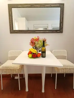 a white table with a bottle of wine and fruit on it at Urban Garden Apartments - Sunflower 2 in Belgrade