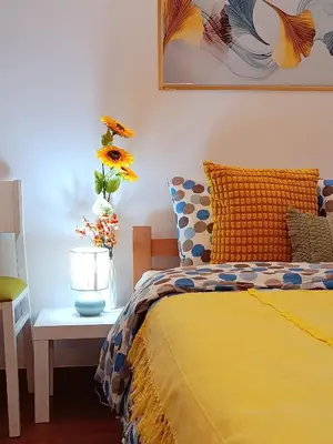 a bedroom with a bed and a table with a vase of flowers at Urban Garden Apartments - Sunflower 2 in Belgrade