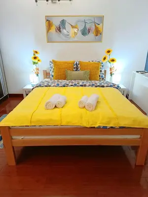 a bedroom with a yellow bed with two towels on it at Urban Garden Apartments - Sunflower 2 in Belgrade