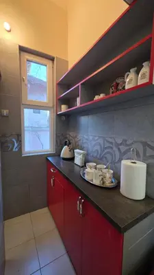 a kitchen with red cabinets and a plate on a counter at Vracar Luxury Apartment in Belgrade