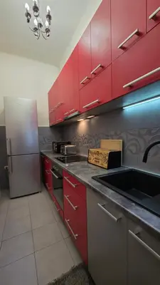 a kitchen with red cabinets and a stainless steel refrigerator at Vracar Luxury Apartment in Belgrade