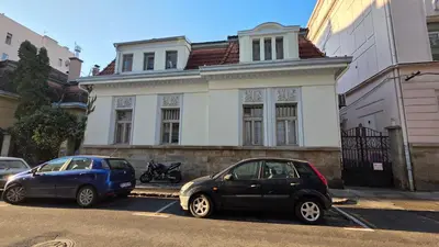 two cars parked in a parking lot in front of a building at Vracar Luxury Apartment in Belgrade