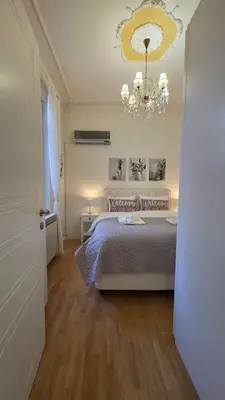 a bedroom with a bed and a chandelier at Vracar Luxury Apartment in Belgrade