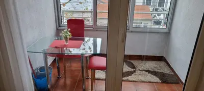 a glass table and a red chair in a room at Vena in Belgrade