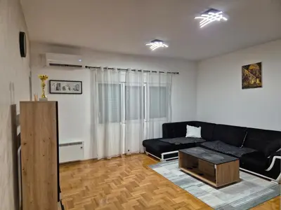 a living room with a black couch and a coffee table at Teja- new apartment for 4 person with free parking space in Belgrade