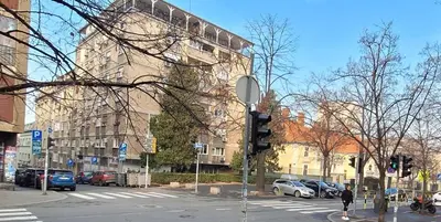 a man is waiting to cross the street at an intersection at Retiro Apartman in Belgrade